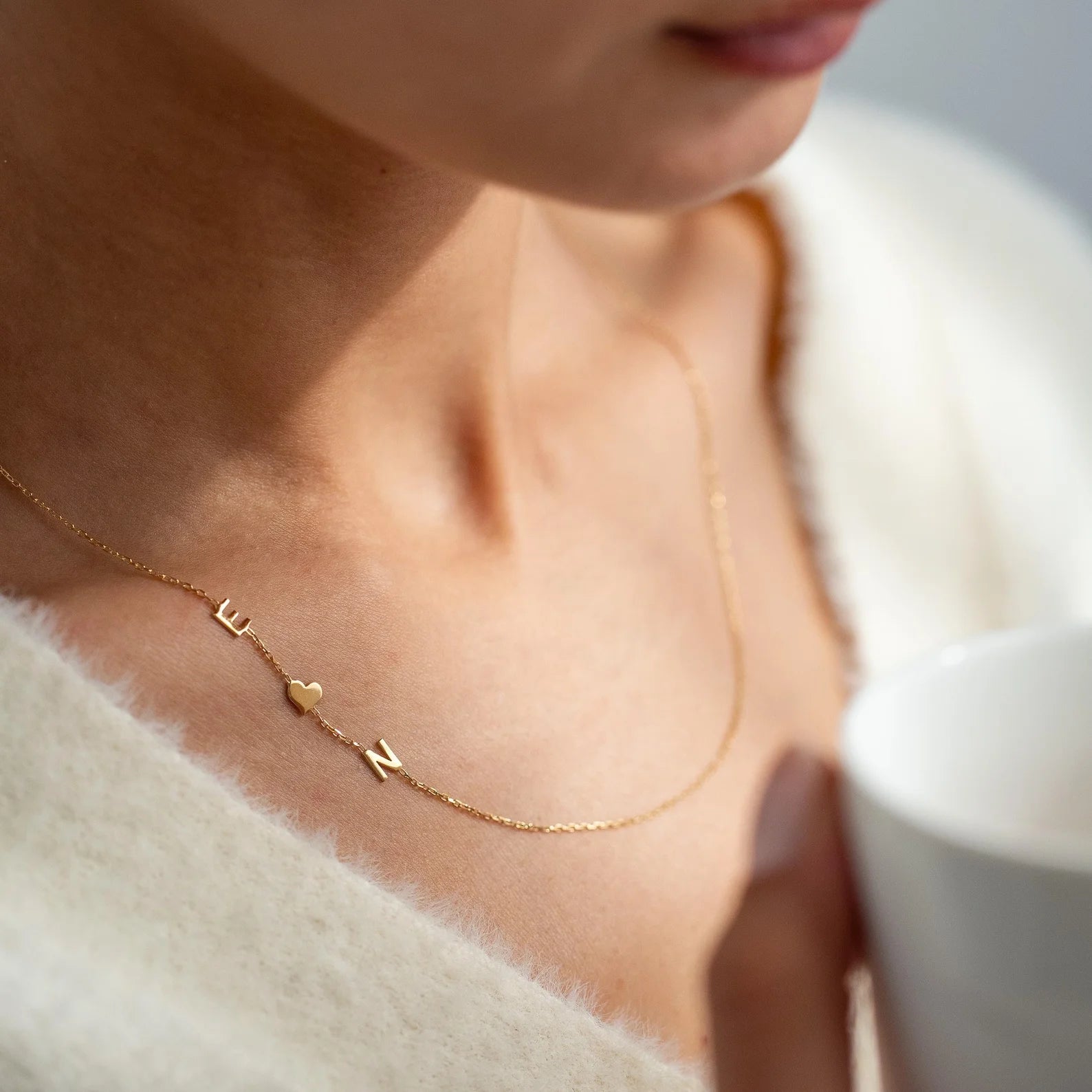 Amoretta Initialen-Kette mit Buchstaben und Herzanhänger, in Gold am Hals getragen, Nahaufnahme