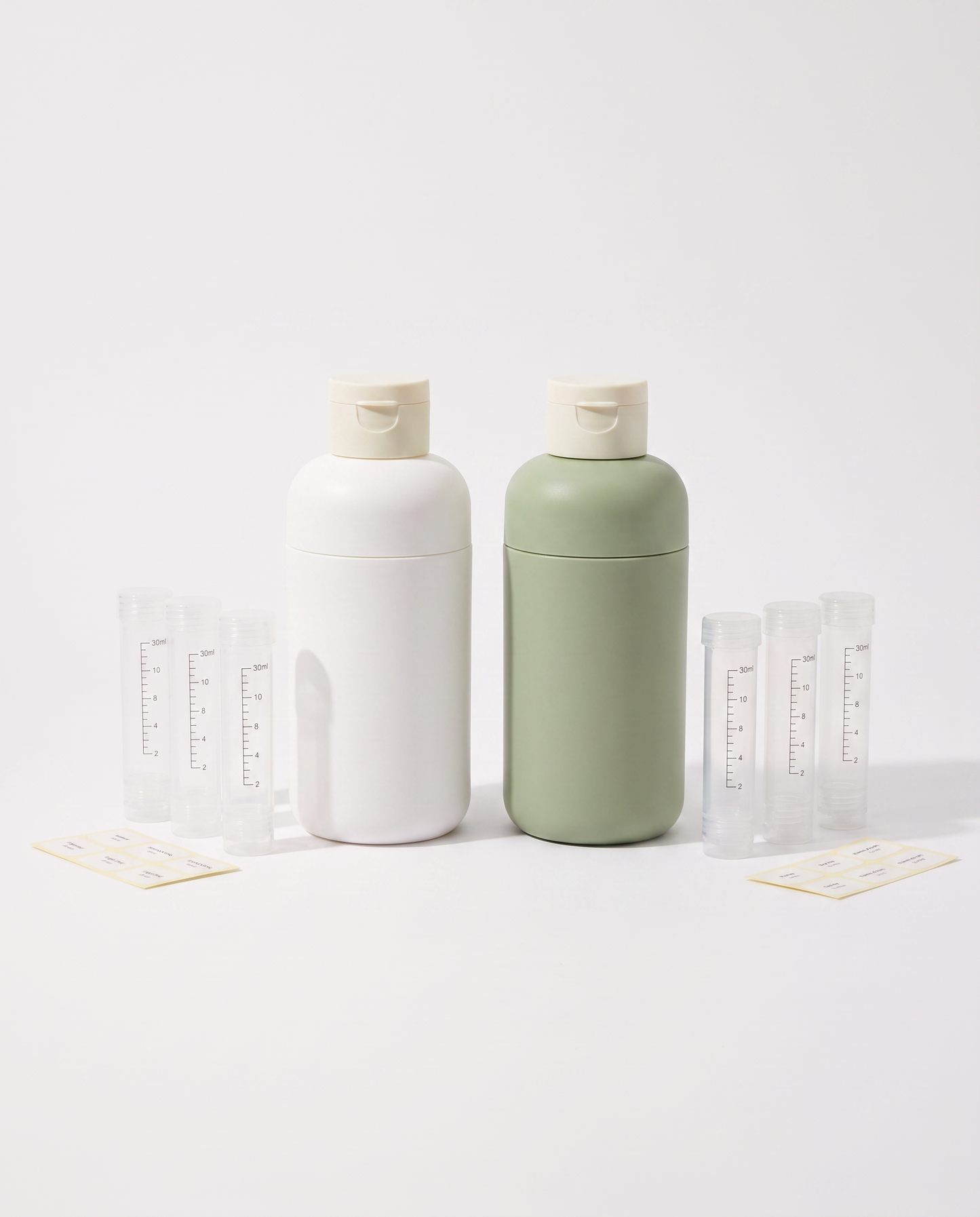 Voyalis 4-in-1 Reise-Dispenser in Elegant Weiß und Matcha-Grün nebeneinander mit Nachfüll-Tuben