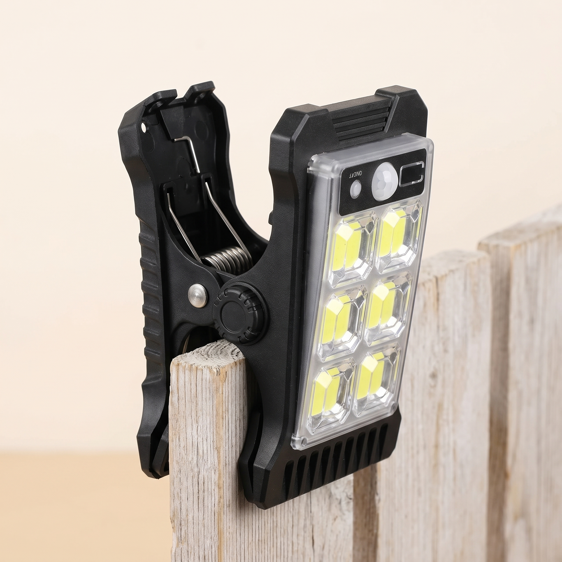 Clipora Solar-Clip-Leuchte mit geöffnetem Klemmmechanismus (Klipp) am Zaun montiert